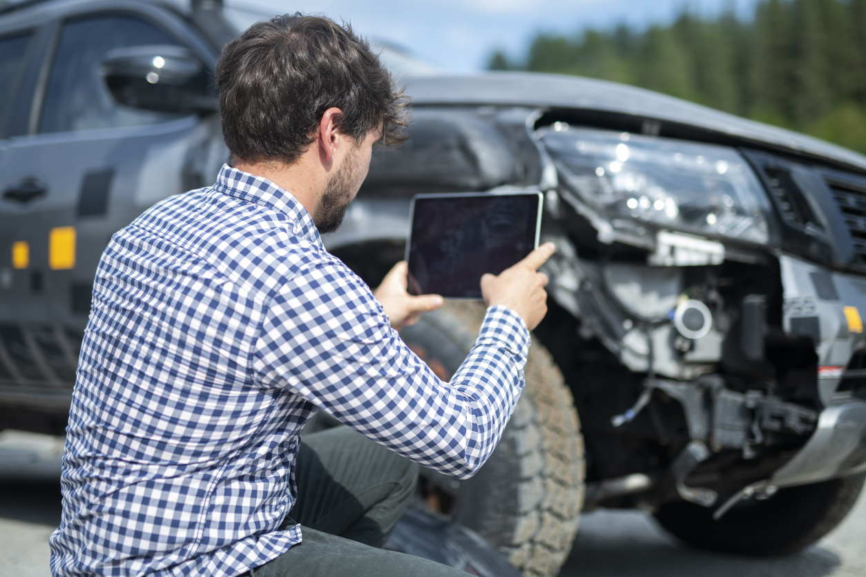 Insurance adjuster inspecting car.